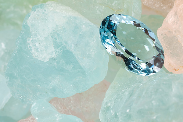 A faceted aquamarine on a light blue-turquoise and beige background