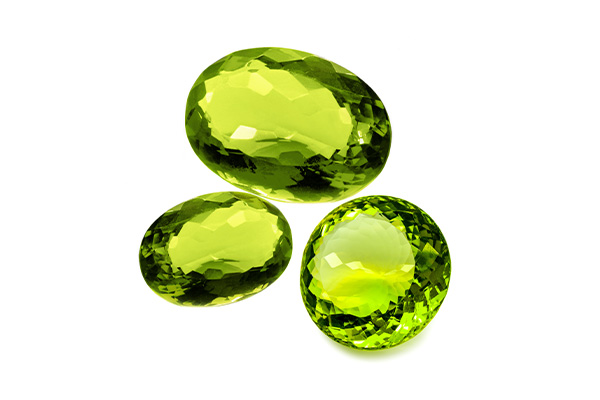 Three peridots with different cuts are depicted side by side on a white background