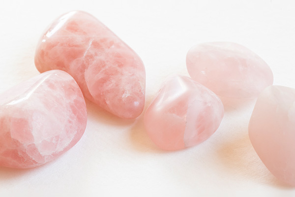 Tres piedras de cuarzo rosa sobre un fondo claro