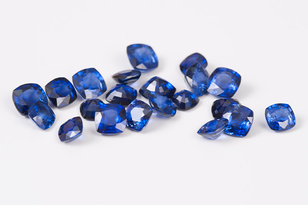 Several faceted sapphires on a gray surface